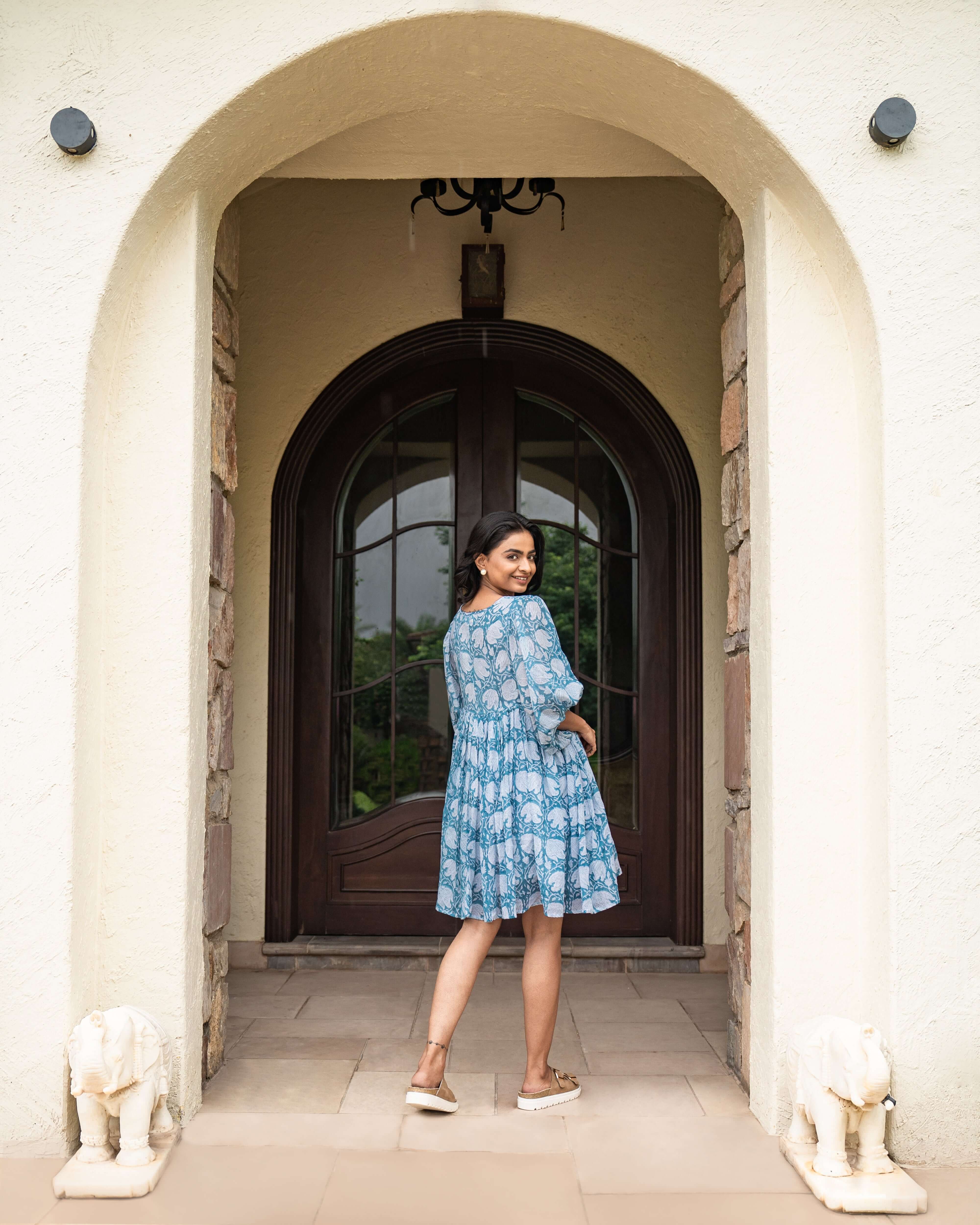 Handcrafted blue cotton midi dress with floral prints, relaxed sleeves, and a flattering silhouette, perfect for casual outings or special events.