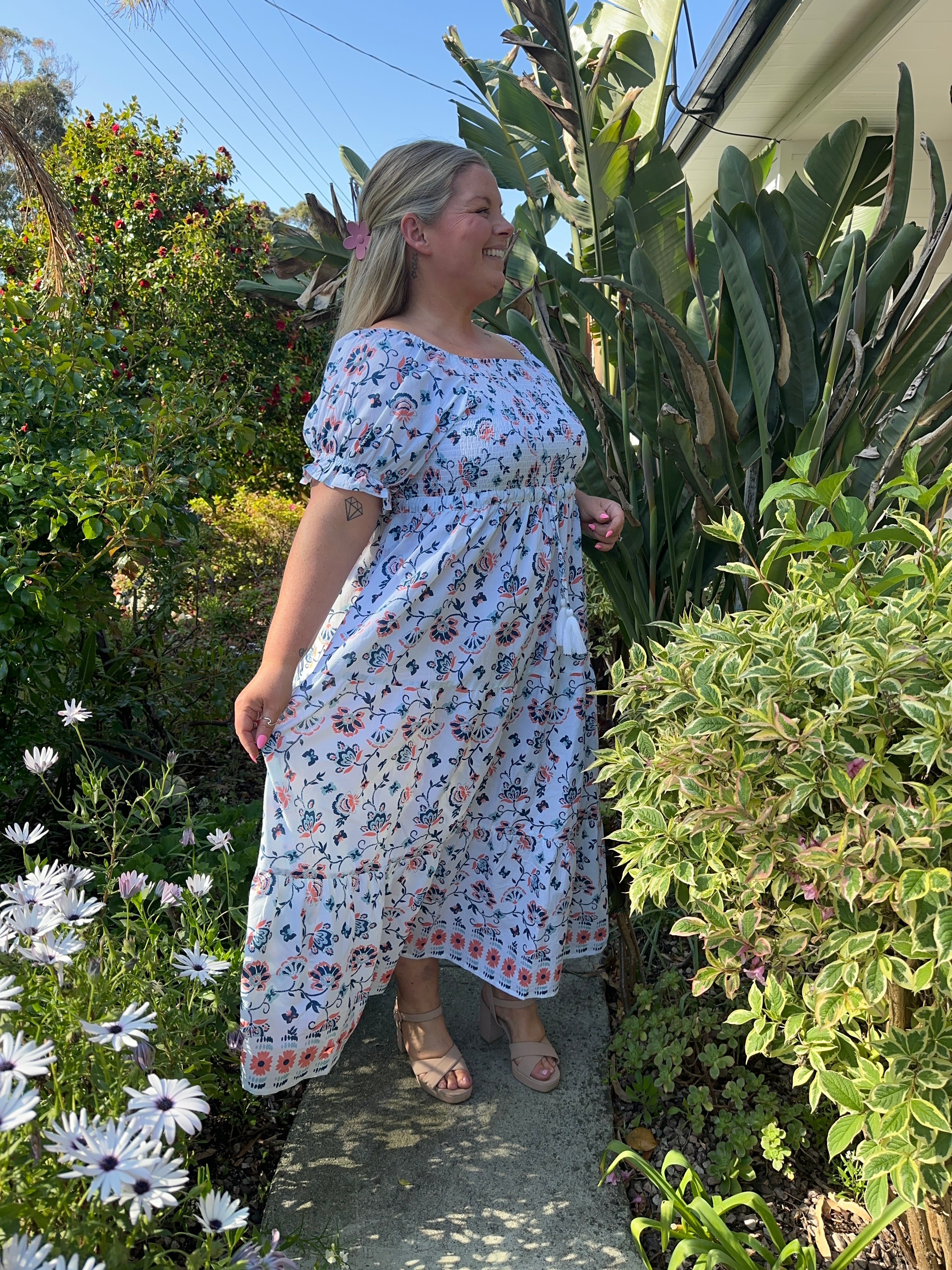Blue maxi dress featuring a fitted shirred bodice and a relaxed, floor-length skirt for a stylish look.