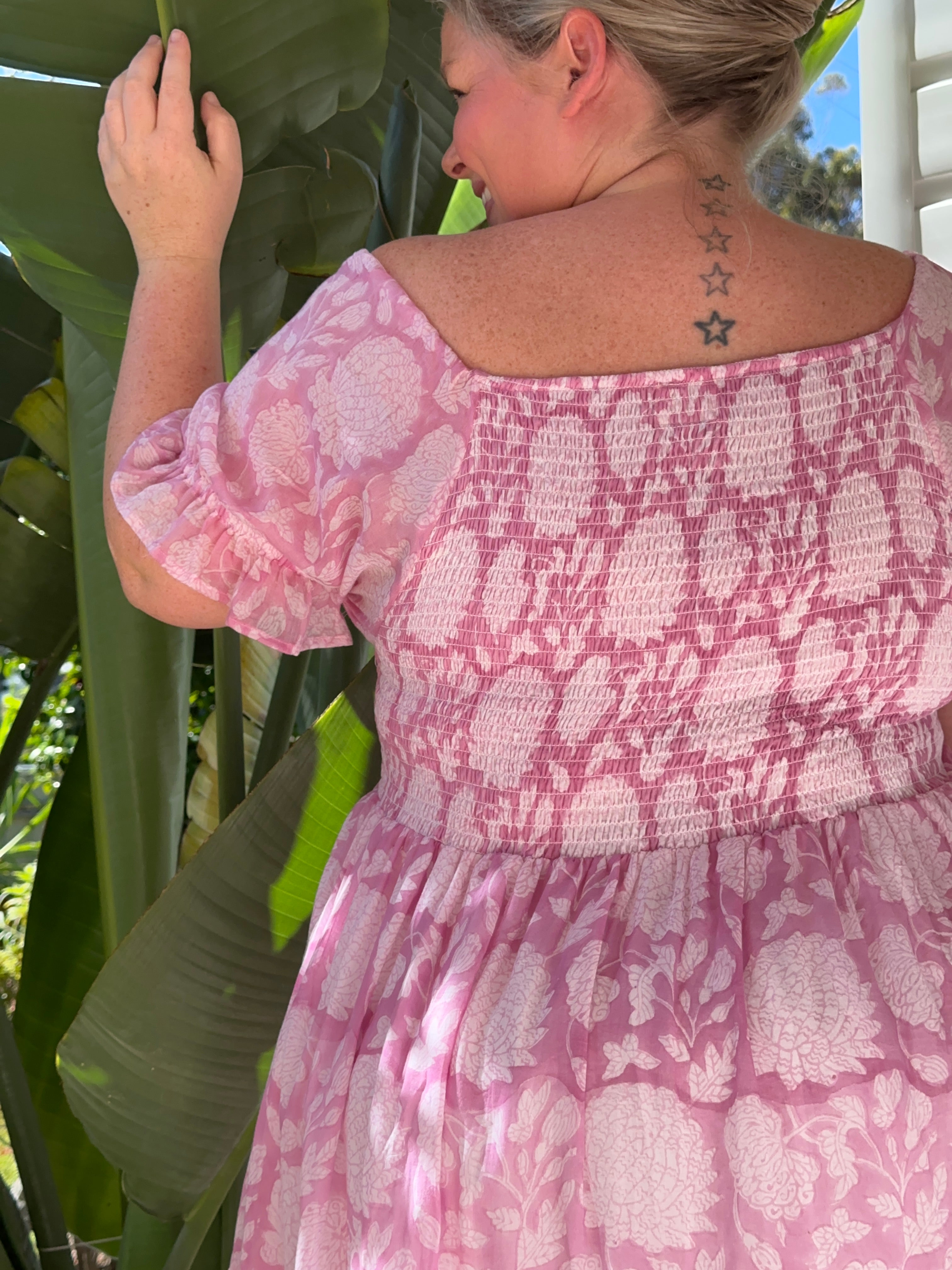 Chic pink floral cotton maxi dress with a flattering shirred top. Ideal for a stylish, breezy day look.