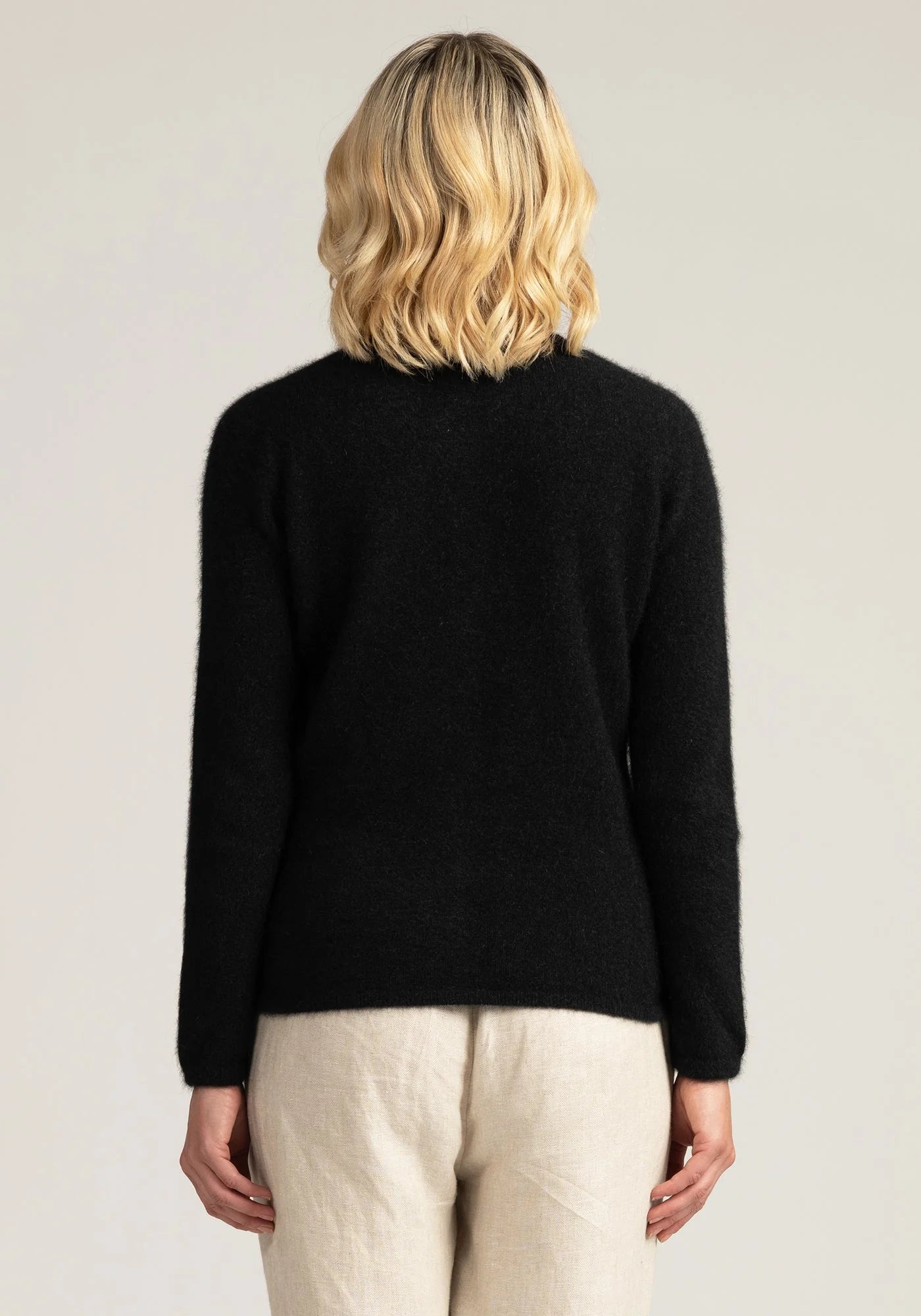 "Stay cozy in style with our black merino wool cardigan. Button up for warmth and sophistication. Shop now!"