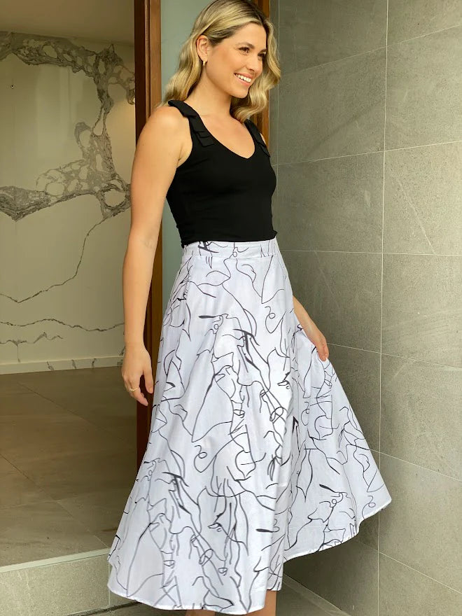 Discover timeless charm with our white maxi skirt in captivating scribble print. Unleash your fashion statement!