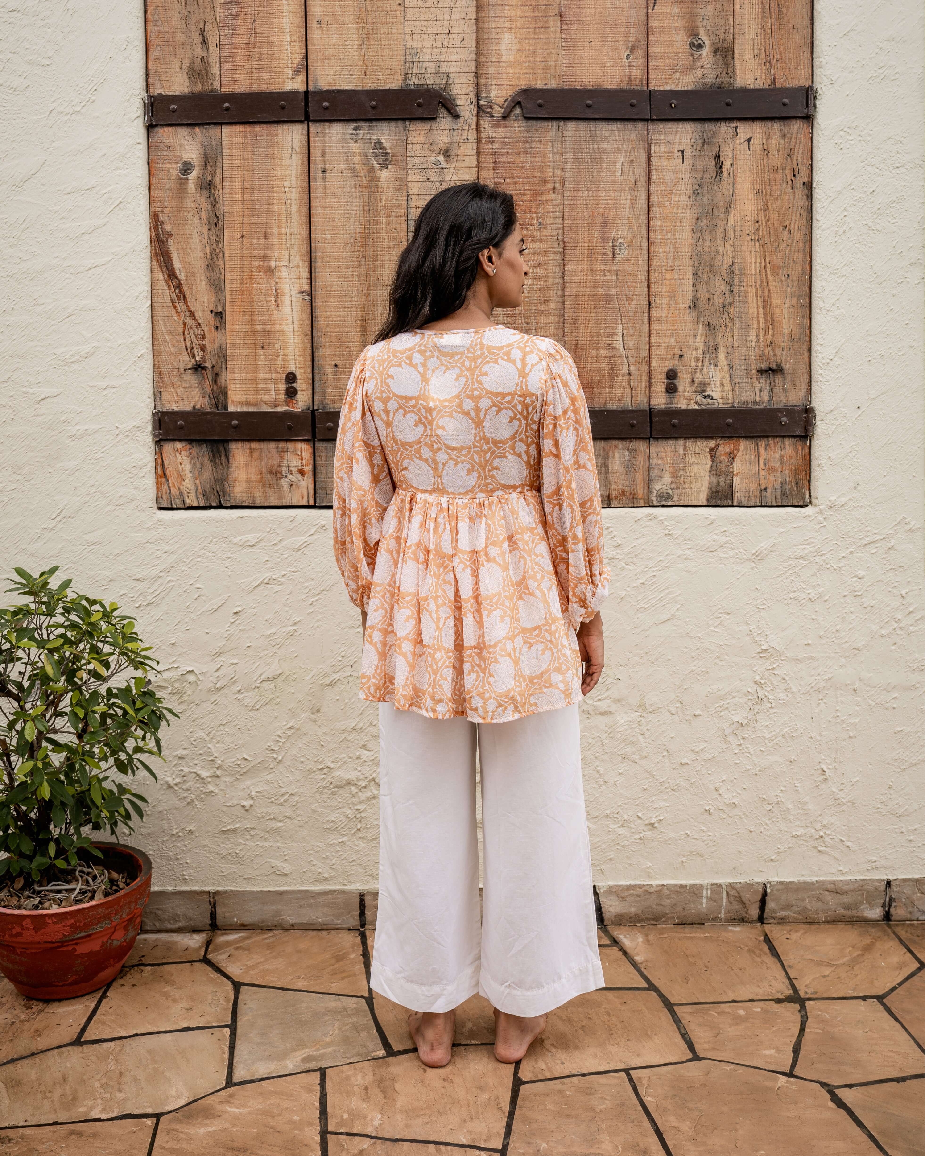 Stylish brown floral top with soft cotton fabric, adjustable cord, and relaxed silhouette, perfect for a casual yet elegant look.