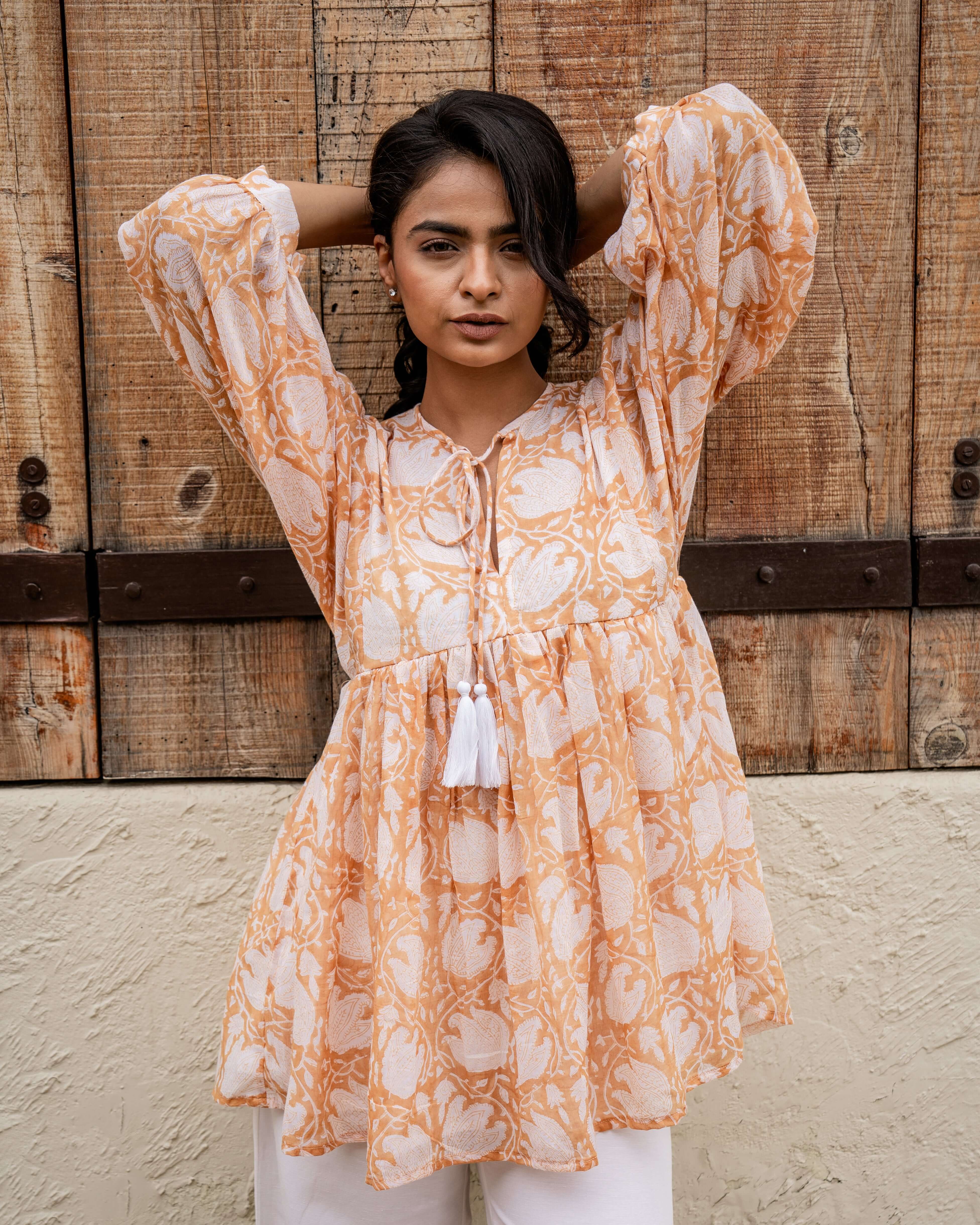 Chic caramel floral top featuring 3/4 sleeves, vintage-inspired block print, and a functional cord for a customizable, comfortable fit.