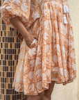 Floral-patterned caramel midi dress in soft cotton, ideal for sunny days or brunch outings, offering comfort and chic style effortlessly.