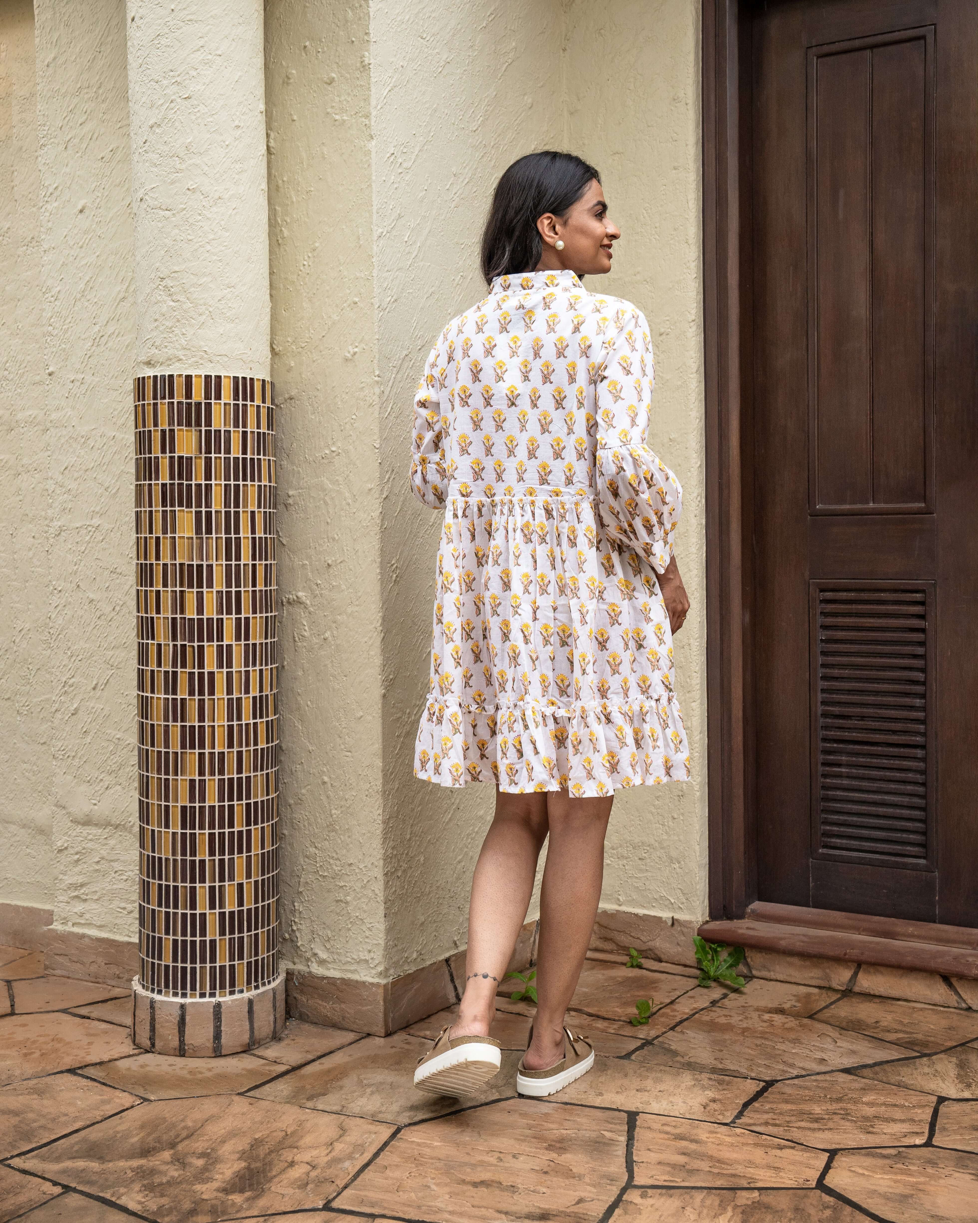 Gorgeous sunflower pattern on white cotton midi dress, designed with long sleeves and a flowy silhouette, perfect for a chic, relaxed look.