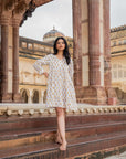 Timeless white cotton midi dress featuring a vibrant sunflower print, long sleeves, and a flowy fit, offering comfort and style for every occasion.