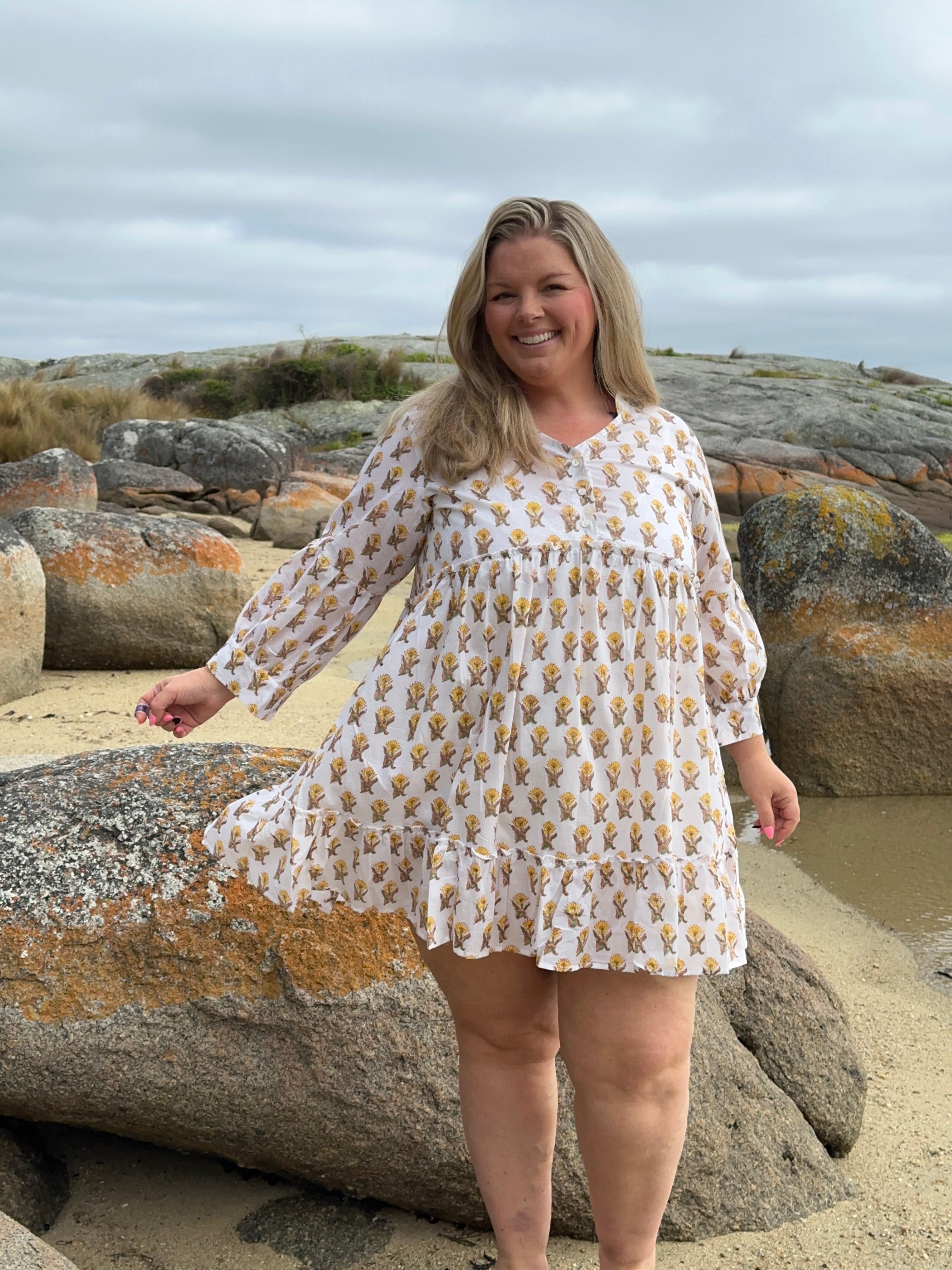 Bright white and yellow cotton midi dress with a floral pattern, perfect for casual summer outings.