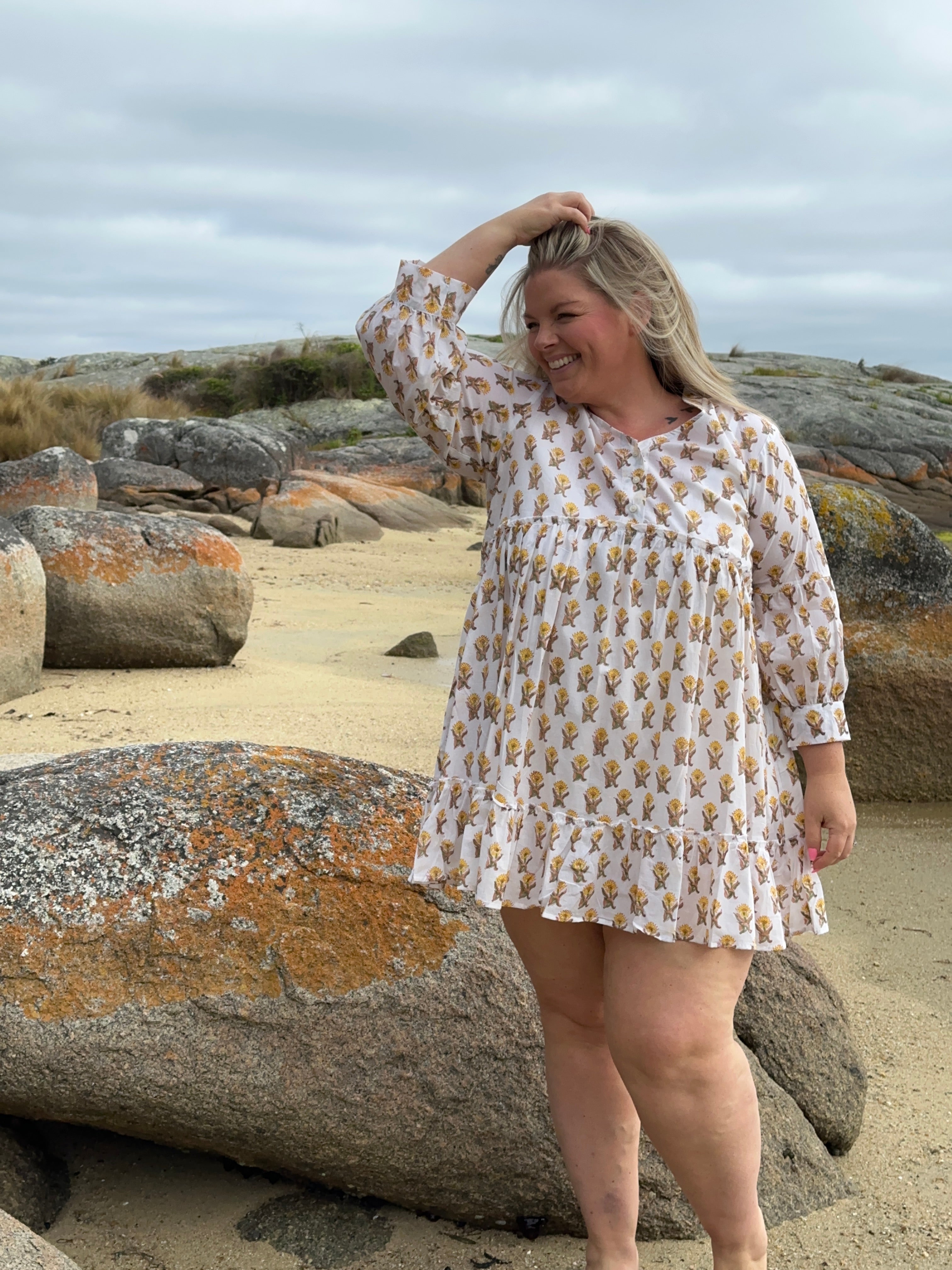 Light and airy white cotton midi dress featuring cheerful yellow accents, ideal for warm-weather events.