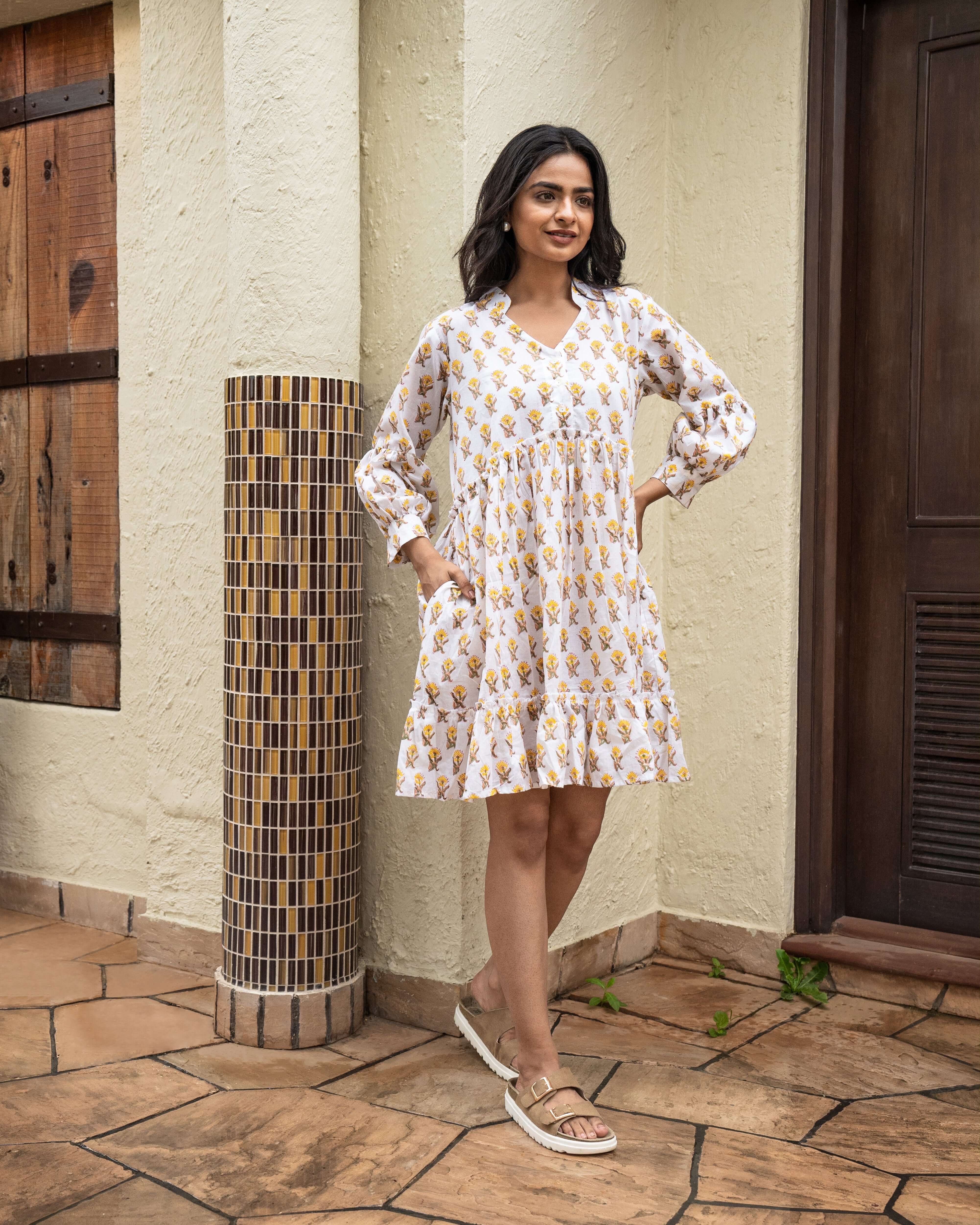 Unique sunflower block-printed midi dress over white, crafted from soft cotton with long sleeves and practical side pockets for everyday elegance.