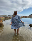 Elegant blue cotton midi dress featuring a fitted bodice and a mid-length skirt, ideal for summer days.