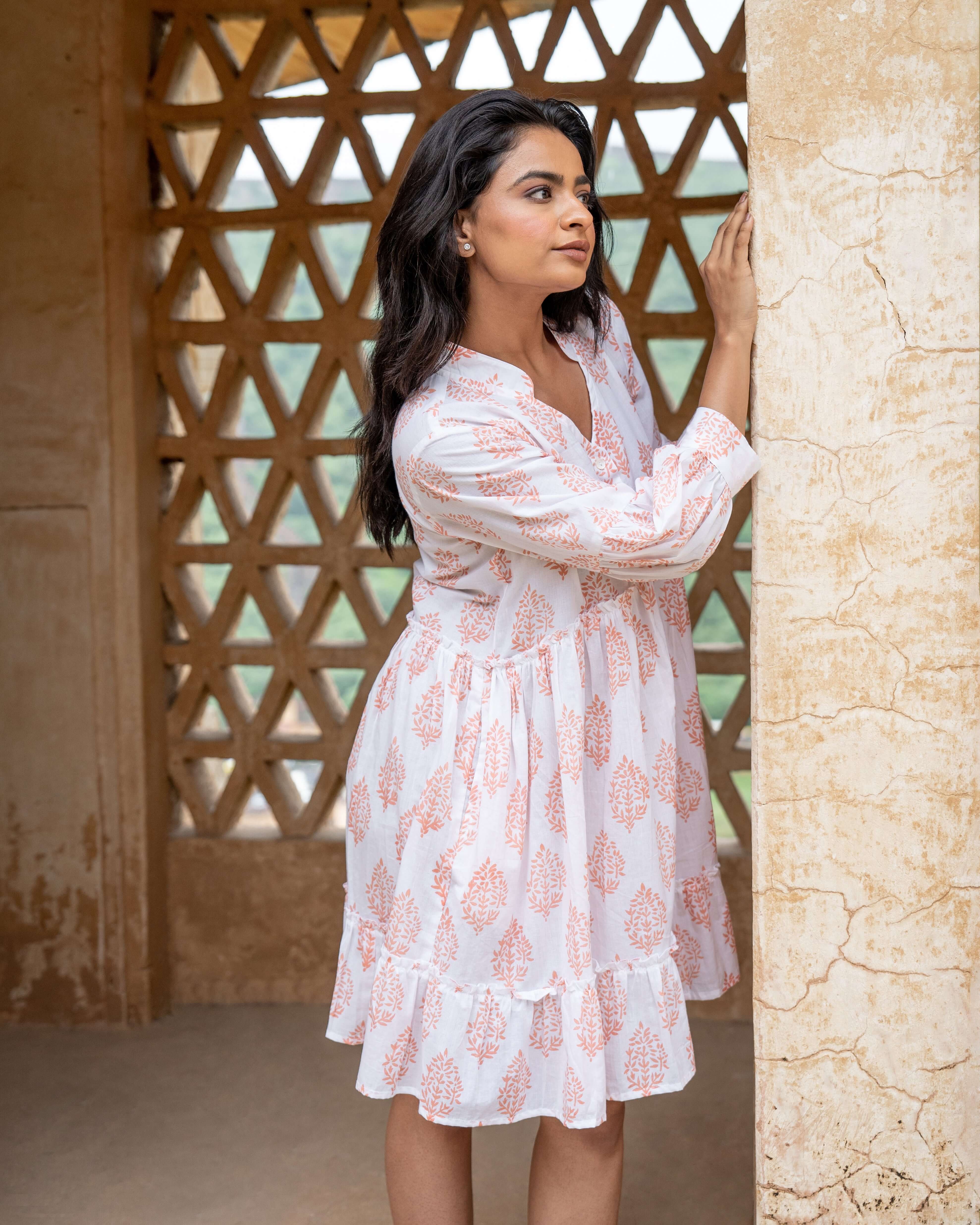 Gorgeous cotton midi dress with terracotta blooms on white, offering long sleeves, a flowy silhouette, and practical side pockets for comfort.