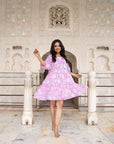 Hand block printed pink cotton midi dress with floral designs, featuring relaxed elastic sleeves, a flattering flowy silhouette, and side pockets.