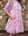 Stunning pink midi dress in soft cotton, featuring intricate floral prints, a flattering silhouette, relaxed sleeves, and convenient side pockets.