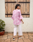 Chic pink floral cotton top with flared 3/4 sleeves and relaxed fit, featuring a vintage block print and hi-low hemline for effortless style.