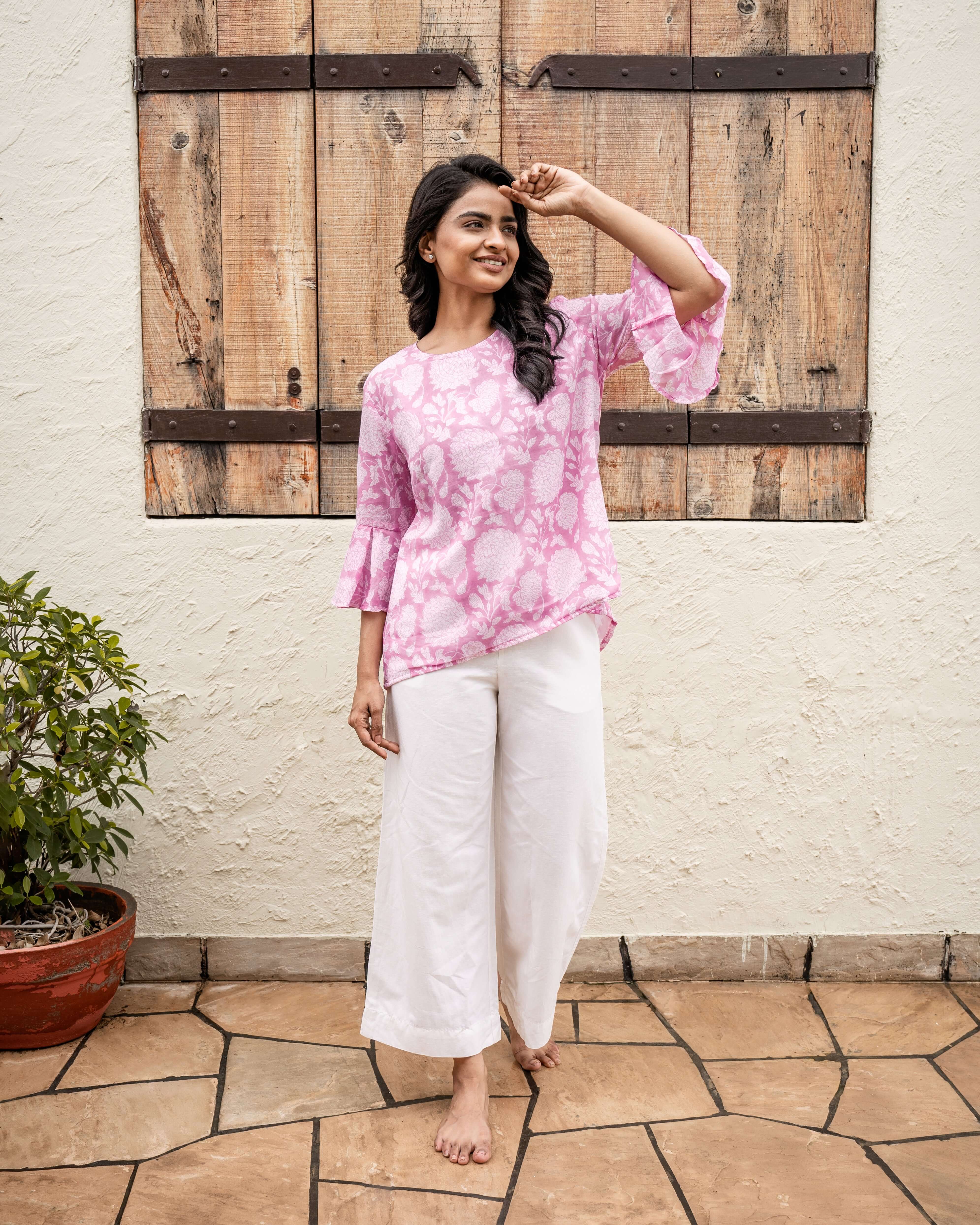 Versatile pink floral cotton top with a hi-low hemline and flared sleeves, handcrafted with a vintage block print for effortless charm.