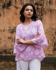 Stylish pink floral top with flared cuffs, round neckline, and a relaxed fit, perfect for pairing with jeans or linen for an easy chic look.