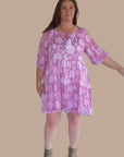 Elegant pink floral midi dress featuring a flattering silhouette and short sleeves, ideal for outdoor events.