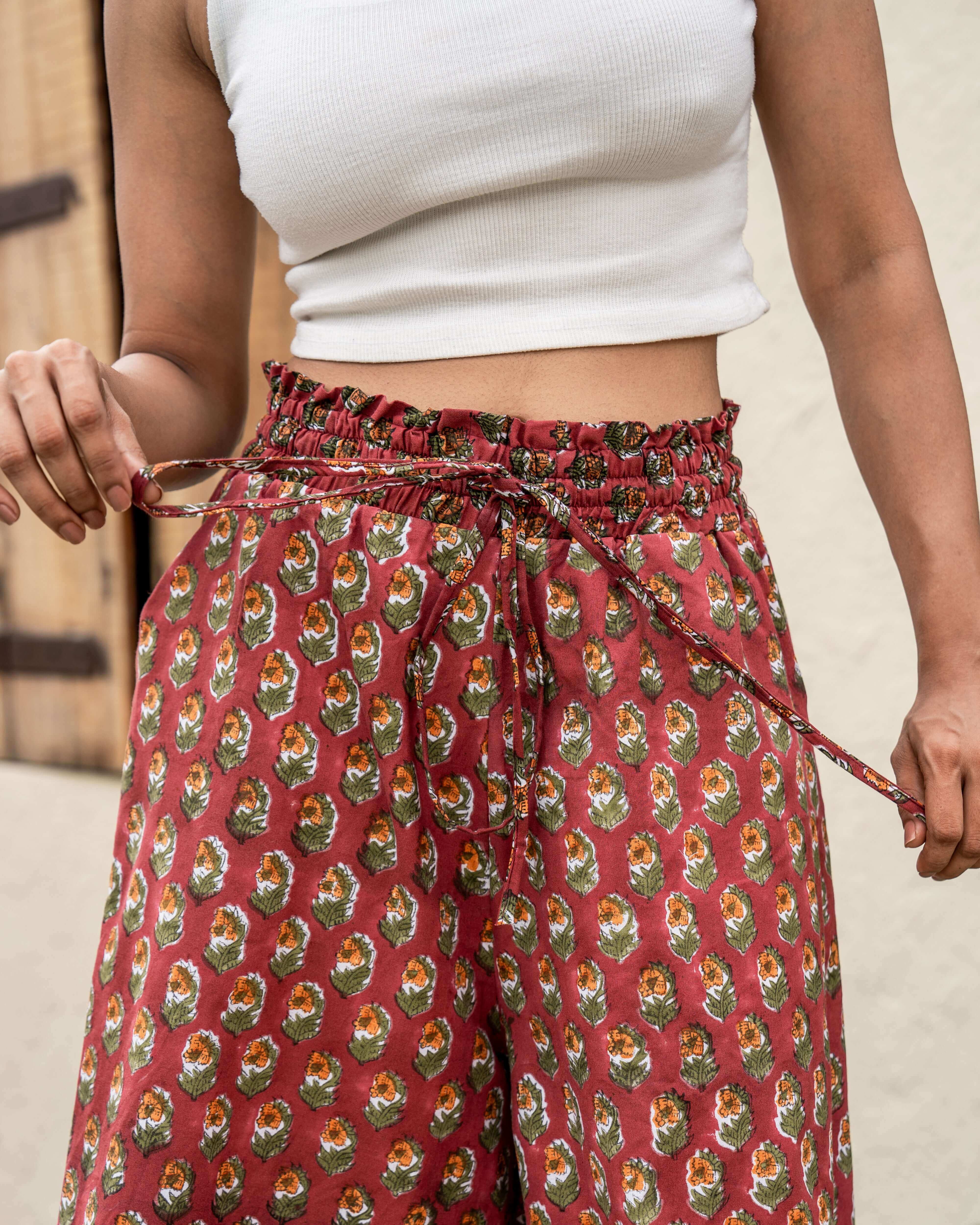 Gorgeous red floral wide leg pants featuring a flowing silhouette and comfortable elastic waist, crafted by skilled artisans for unique charm.