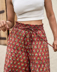 Gorgeous red floral wide leg pants featuring a flowing silhouette and comfortable elastic waist, crafted by skilled artisans for unique charm.