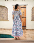 Gorgeous cotton maxi dress with enchanting blue and orange floral prints, featuring a flattering shirred top and relaxed silhouette for effortless wear.