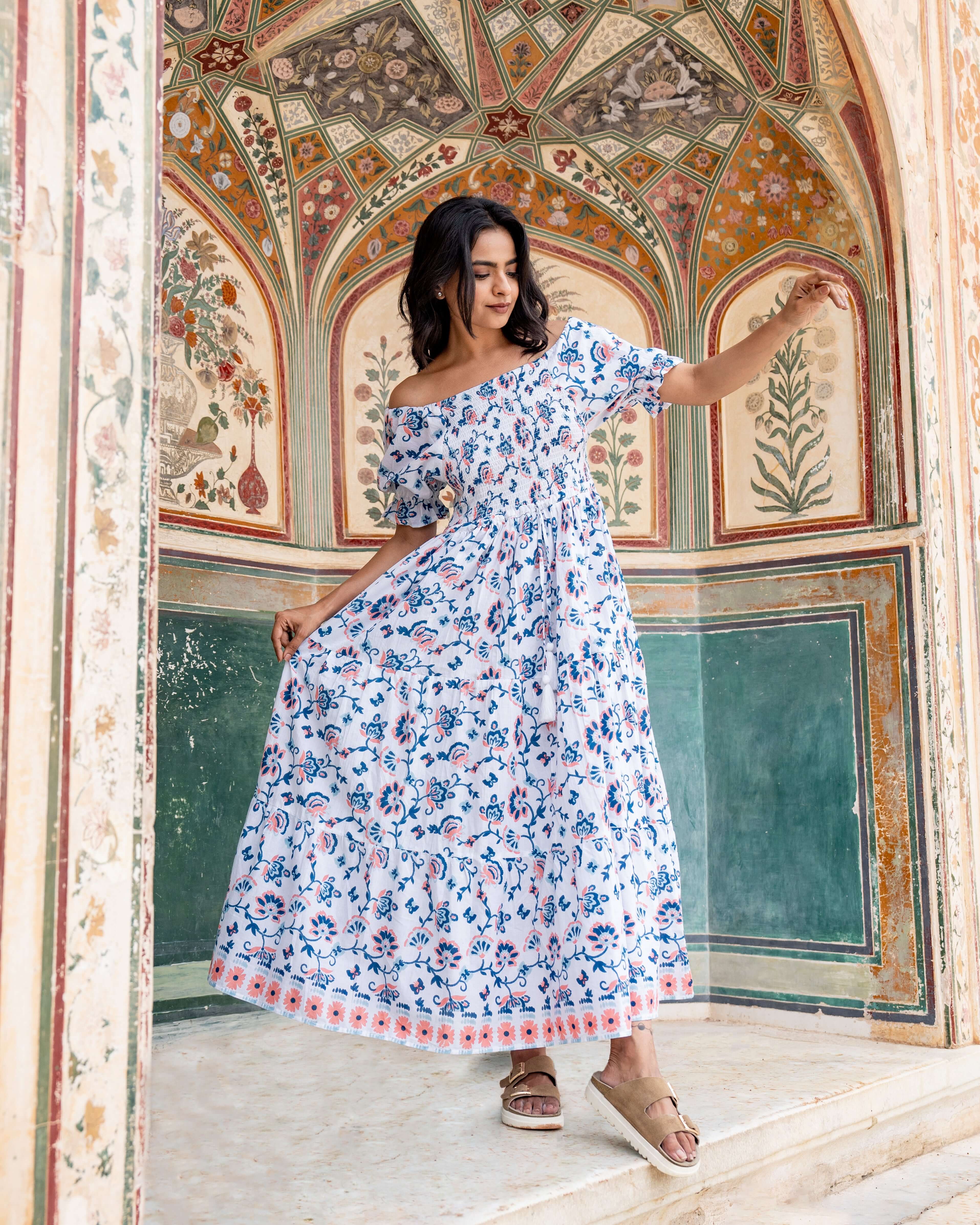 Chic blue and orange print maxi dress with a shirred top and elastic sleeves, crafted from soft cotton for a stylish and comfortable look.