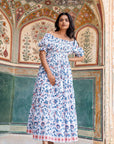 Handcrafted blue and orange floral maxi dress with a shirred design, relaxed fit, and practical side pockets for timeless elegance and comfort.