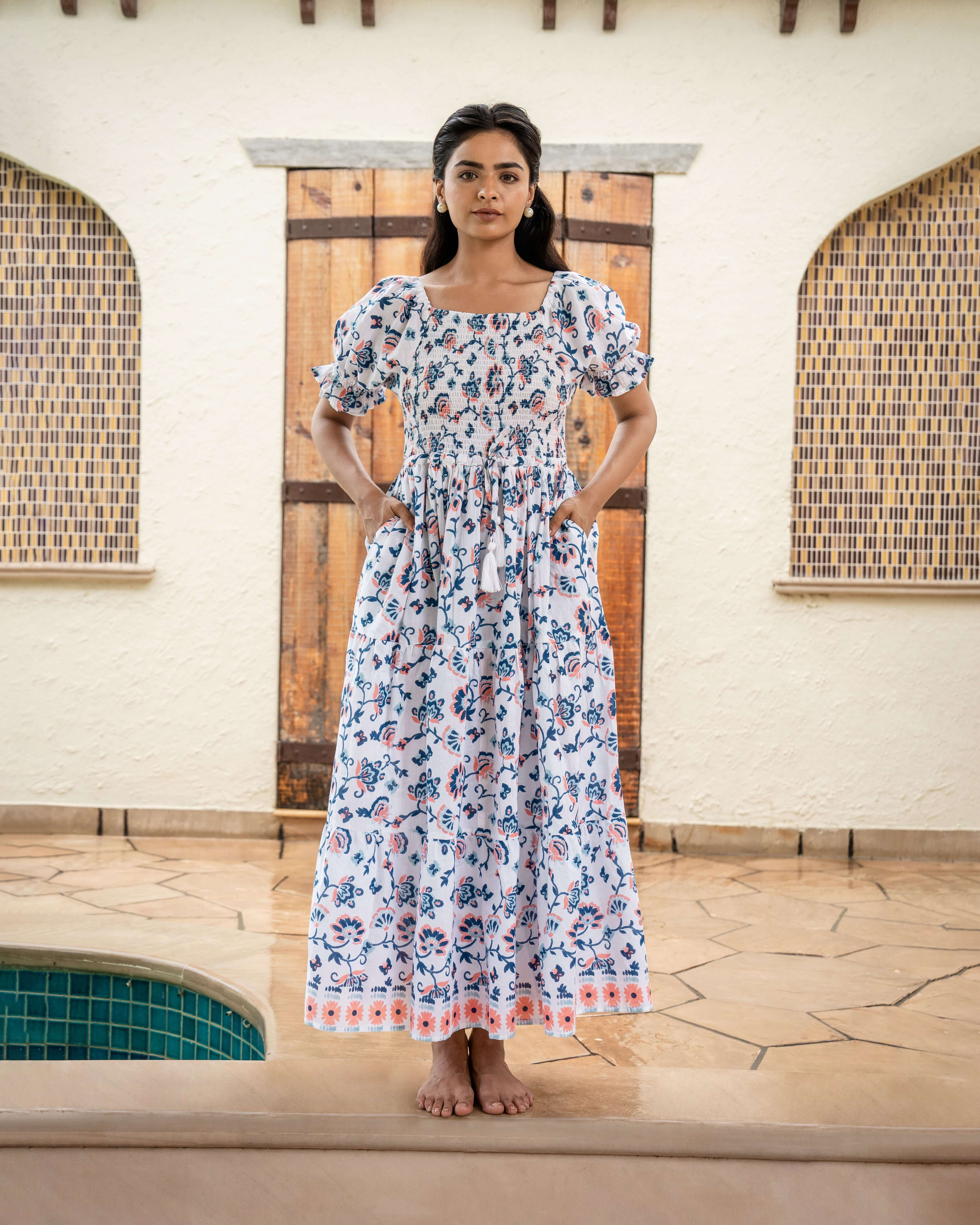 Versatile blue and orange floral maxi dress over white, showcasing a stylish shirred chest and elastic sleeves, perfect for any occasion.