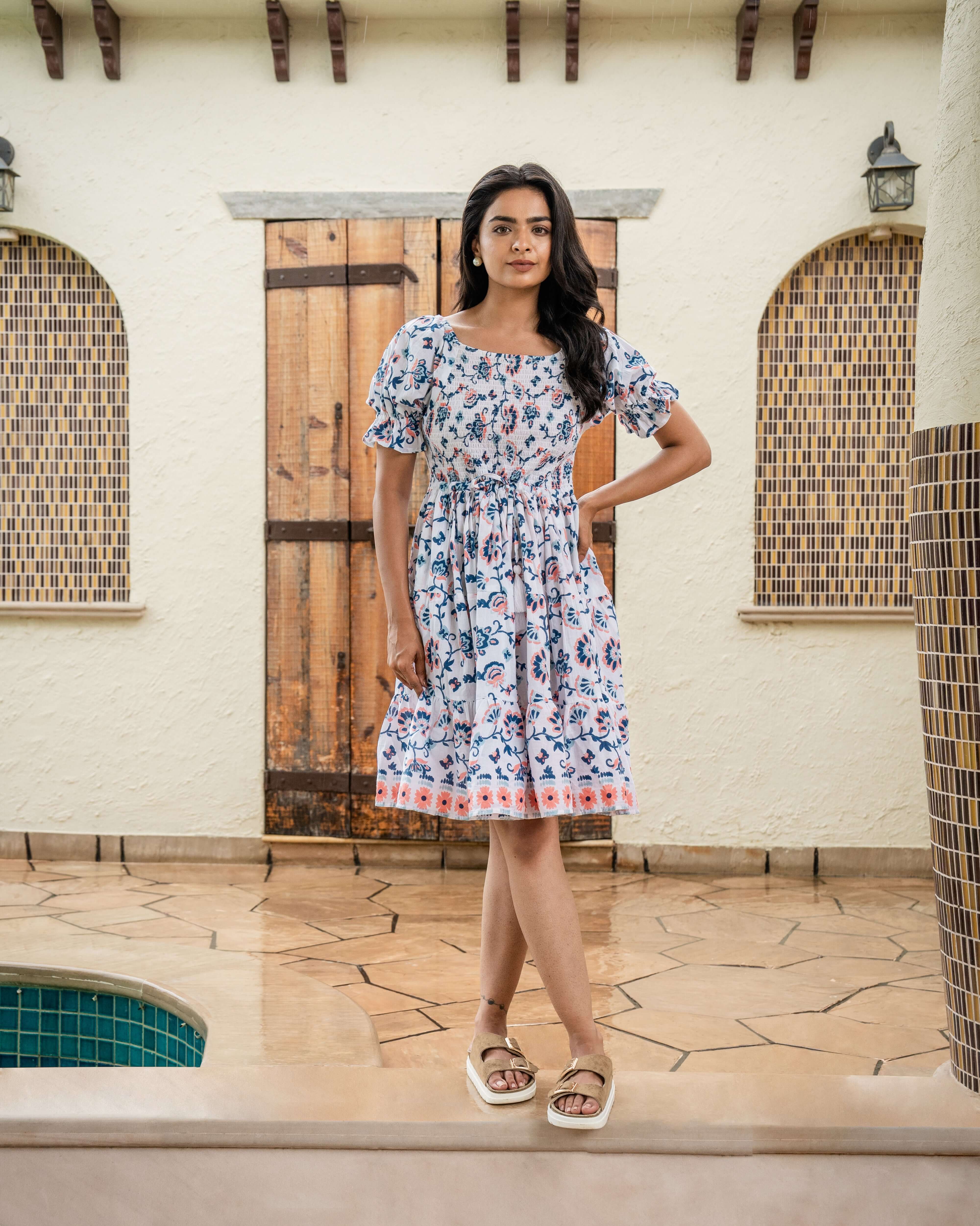 Chic blue and peach print midi dress with a shirred top and elastic sleeves, crafted from soft cotton for a comfortable and stylish look.