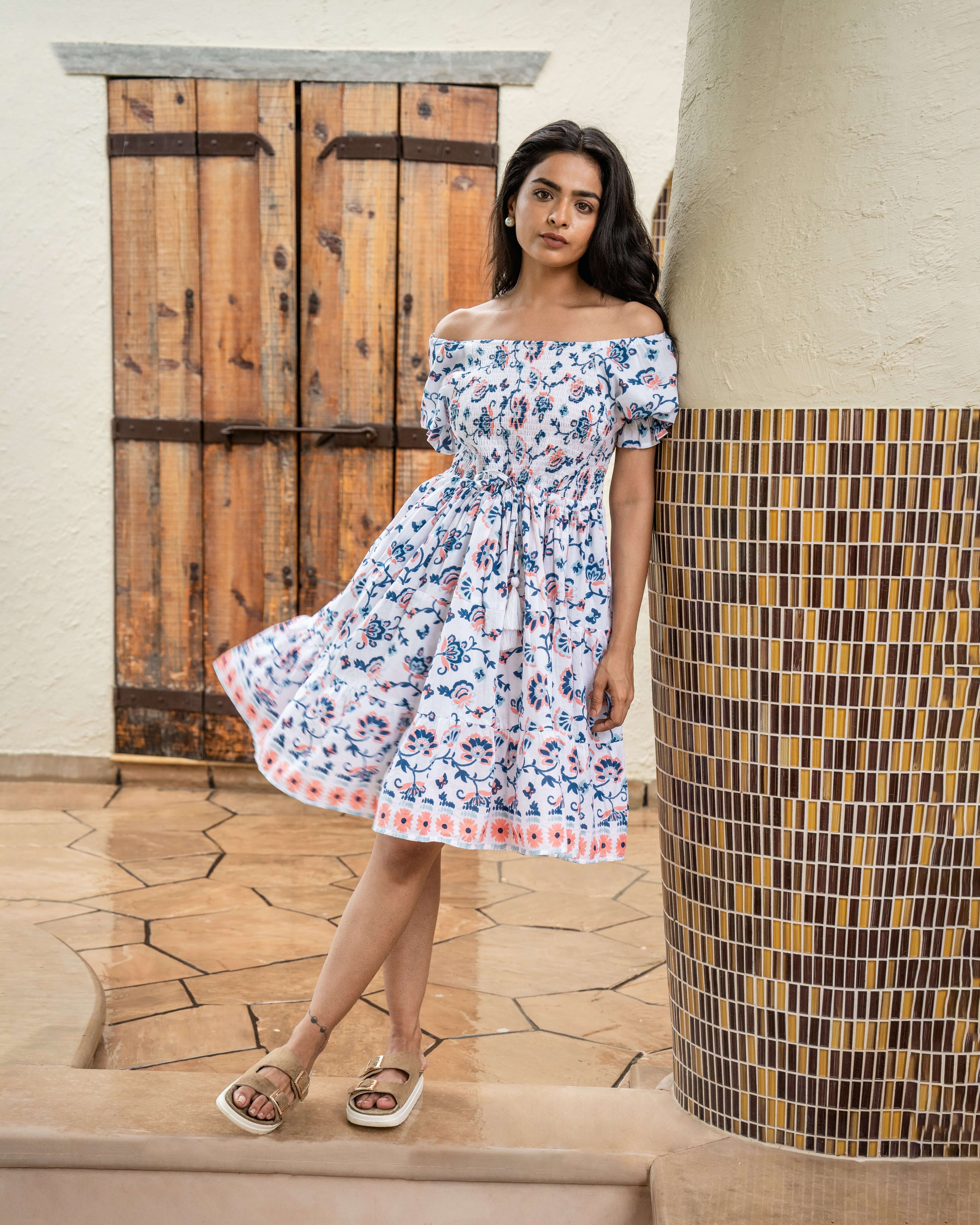 Handcrafted blue and peach floral midi dress with a shirred design, relaxed fit, and side pockets for practicality and timeless elegance.