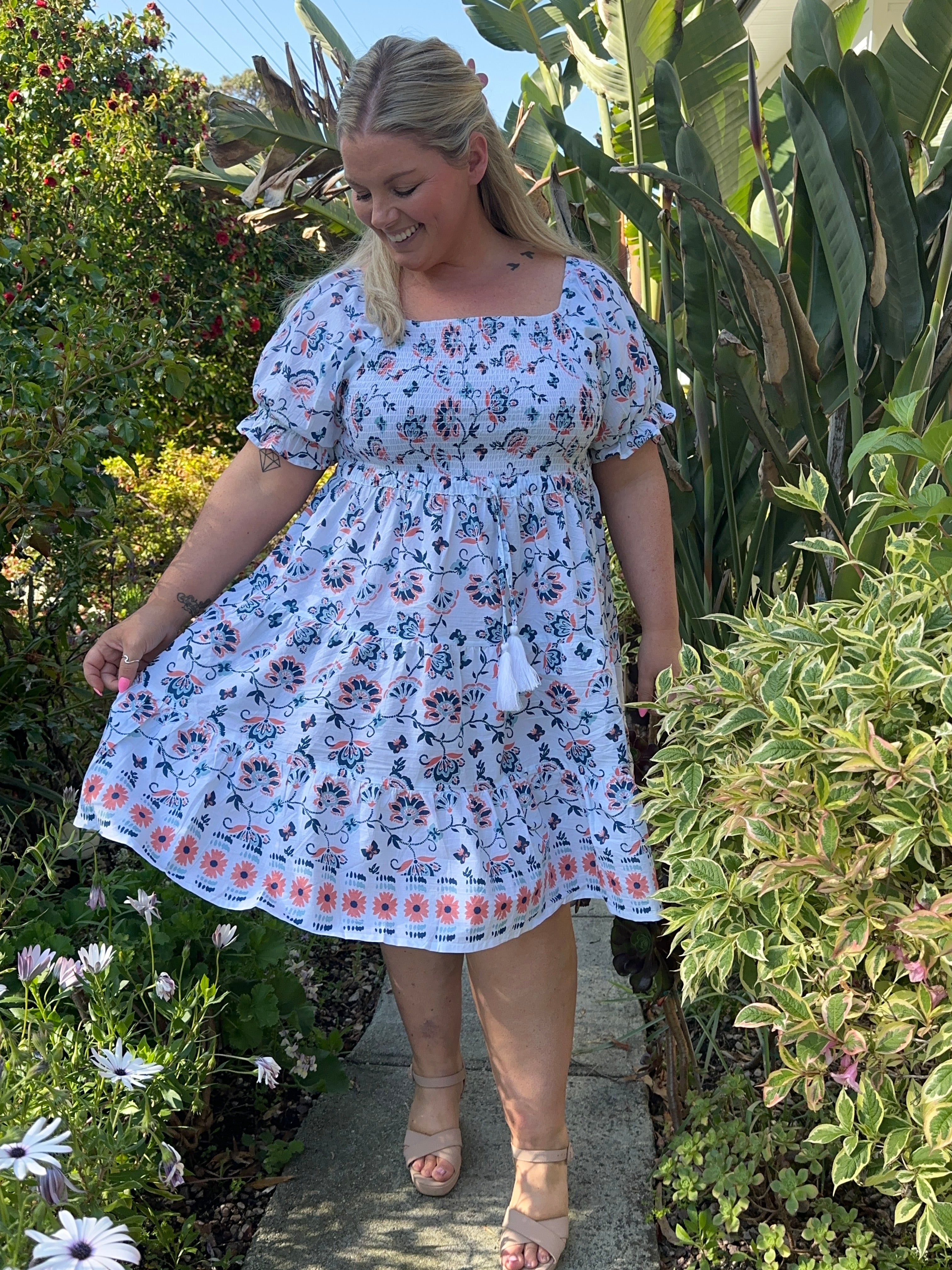 Stylish blue midi dress featuring a shirred top and a flowing skirt, perfect for a casual summer outing.