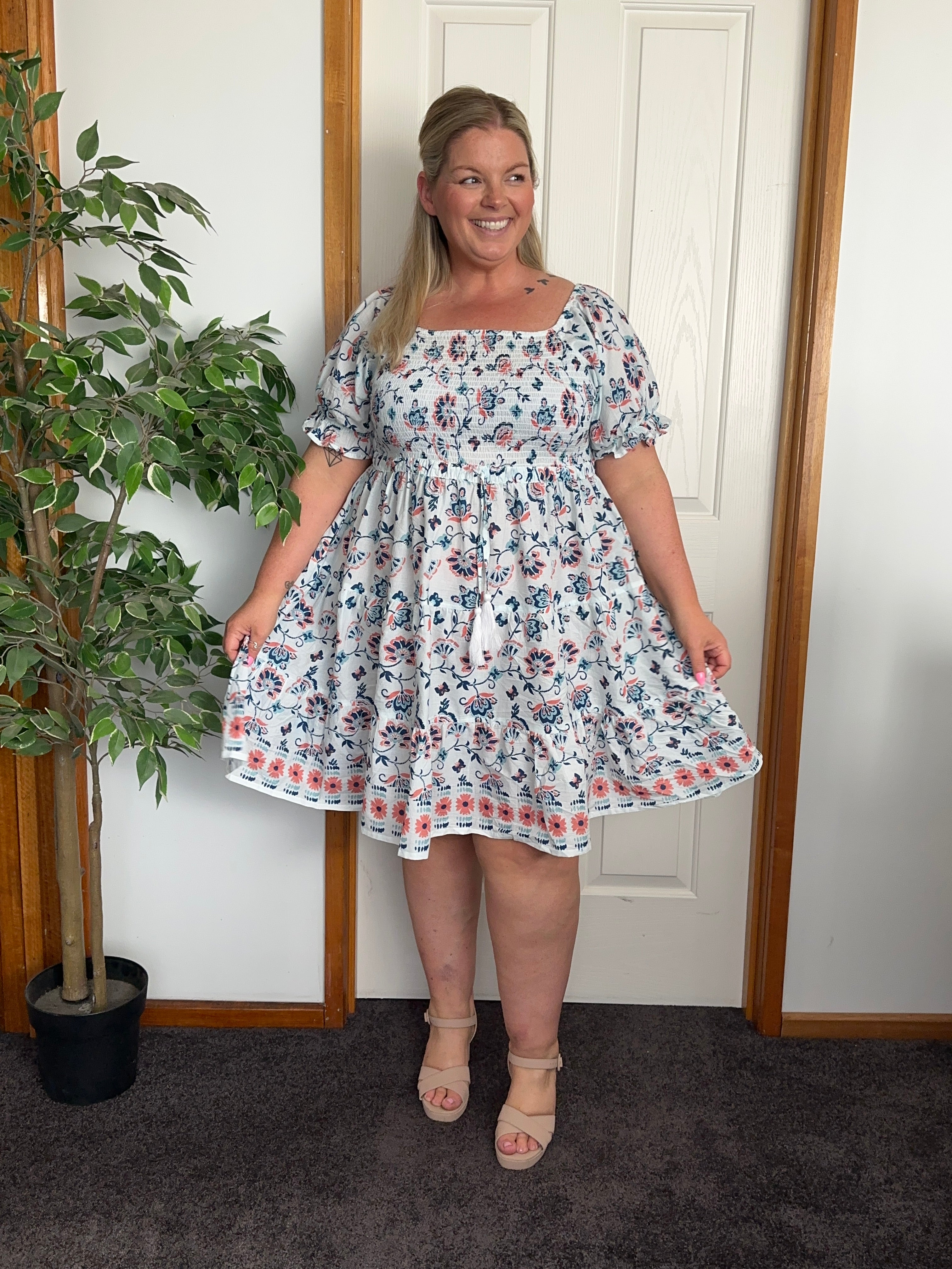 Blue midi dress featuring a fitted shirred bodice and a flowing, mid-length skirt.