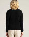 "Stay cozy in style with our black merino wool cardigan. Button up for warmth and sophistication. Shop now!"