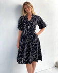 Discover timeless elegance in our black cotton midi dress with a unique scribble print. Get yours today!