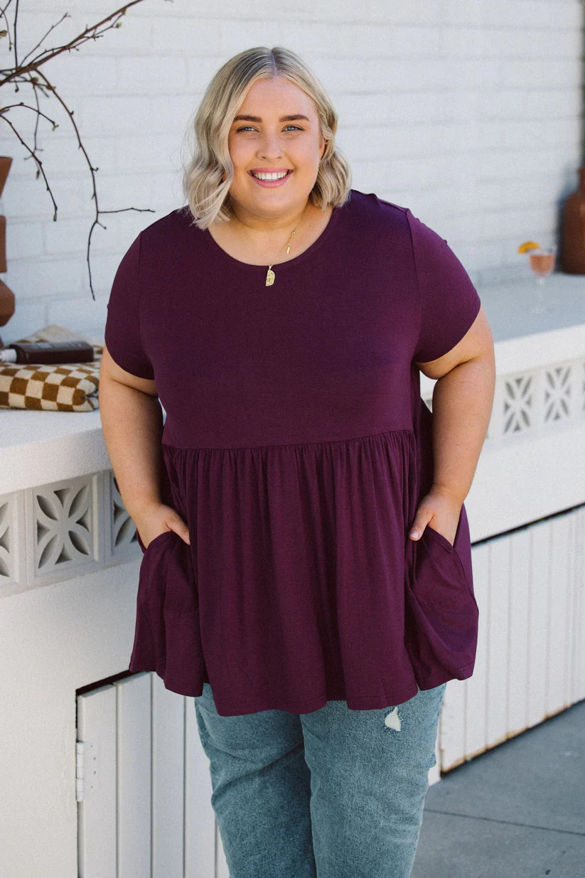 "Embrace your curves in style with our berry-purple baby doll top. Flattering fit for every size. Shop now!"