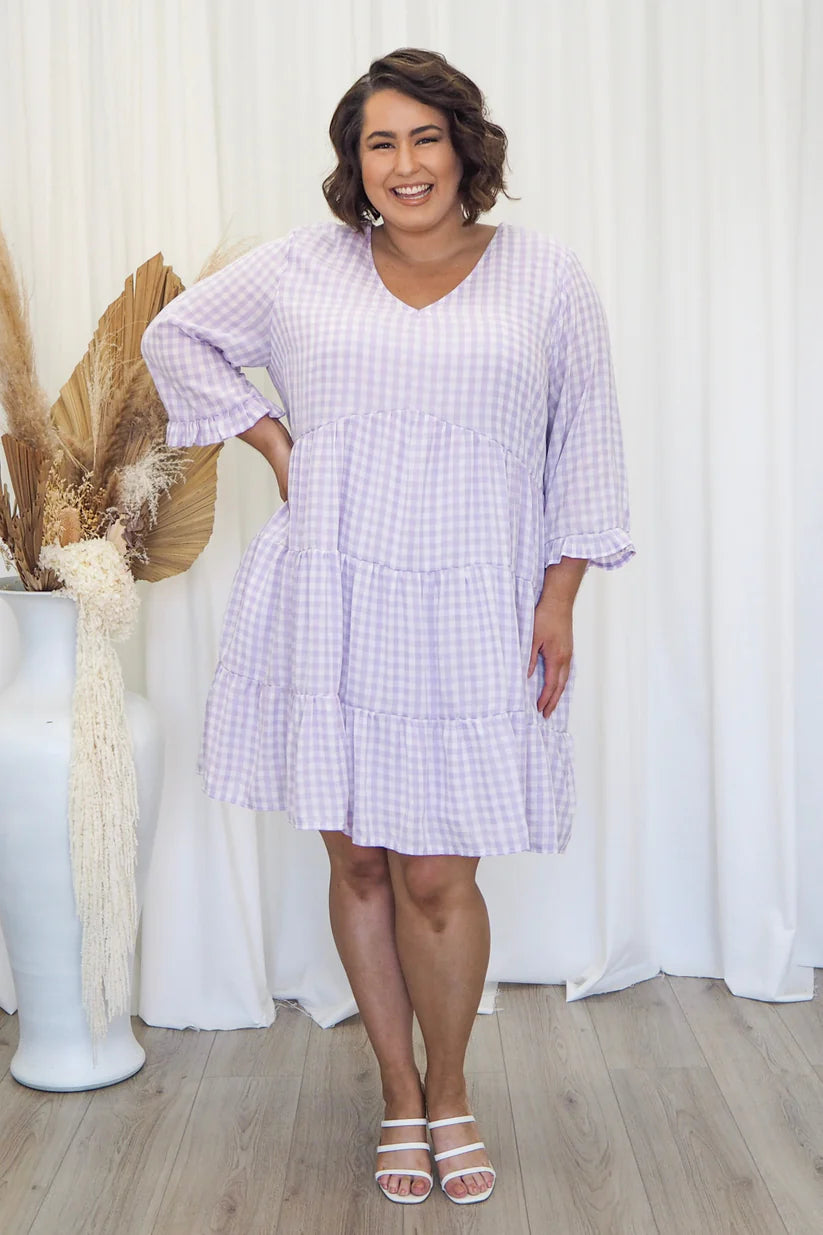 Own the room in our lilac gingham dress! Plus-size glamour with a touch of sophistication. Elevate your style today.